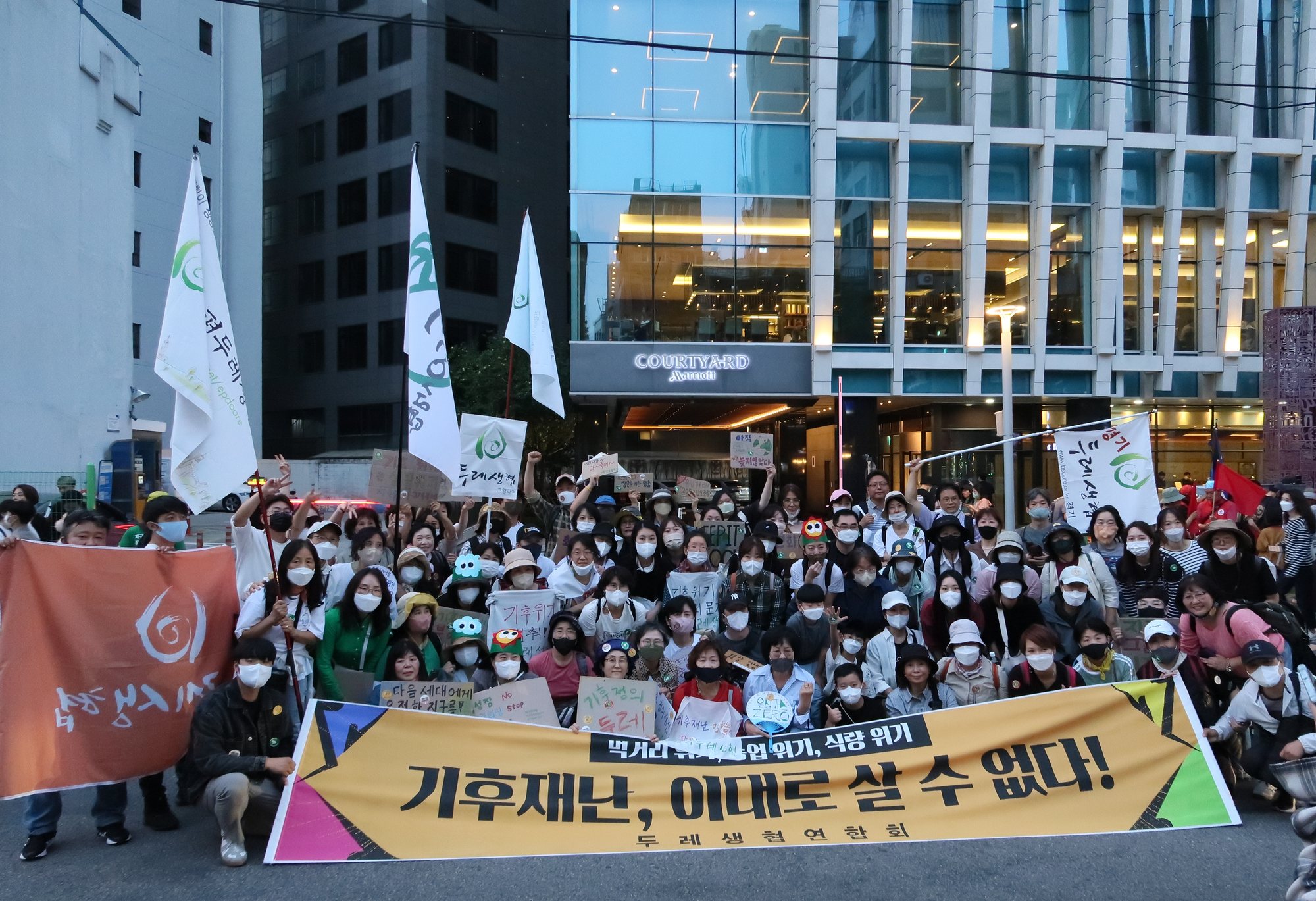 ‘기후재난, 애터로 살 수 없다’ 현수막 앞에 모인 두레생협 조합원들의 924 기후정의행진 단체사진